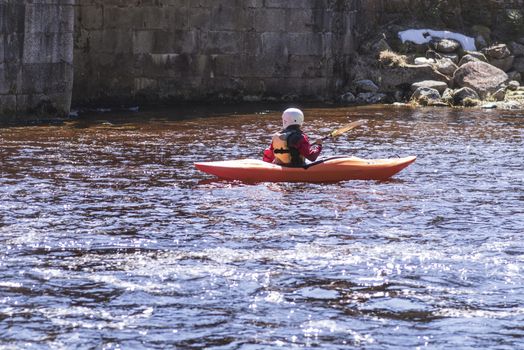 A view of the sport is kayaking.Woman on the kayak.Woman on the bank of the river are resting pouring water from boats, carrying kayak to river.