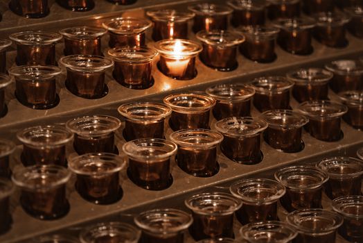 Candles in the church.Many candle flames glowing in the dark.