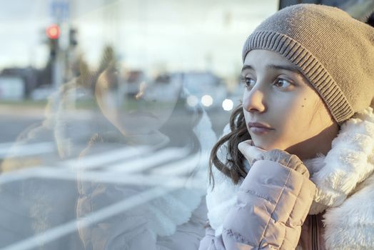 Teenager girl.Girl teenager sits on the bus and looks out the window,teenager girl is sitting in the bus looking forward thinking.