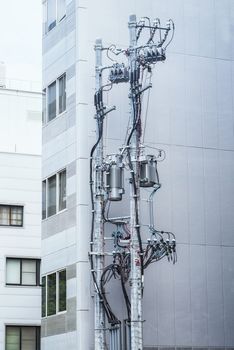 Modern poles with electricity cables on the background of a residential building, poles with electric wires, telecommunication pole .