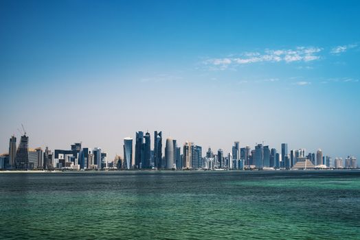 DOHA, QATAR - 4 AUGUST 2018: The modern city of Doha with palm tree, cars, wide avenues on a blue sky in Doha City, capital of Qatar.Doha City.