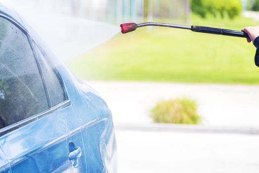 Cleaning Car Using High Pressure Water.Manual car wash with pressurized water in car wash outside.