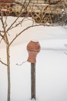 Traditional clay pot on a wooden fence. A brown clay pot .