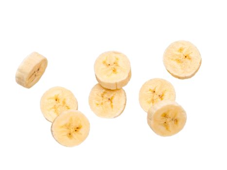 Many banana slices falling, isolated on white background with clipping path. Studio shoot.