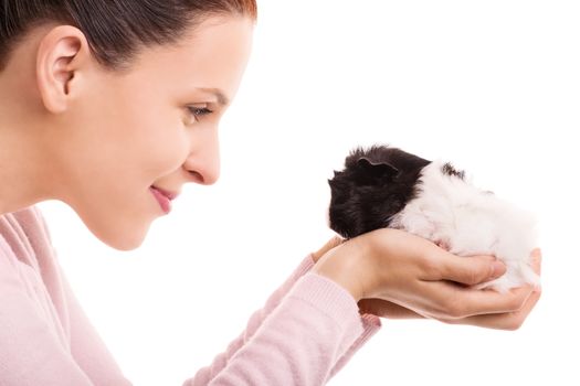 A portrait of a young beautiful woman looking at her pet guinea pig and smiling, isolated on white background.

