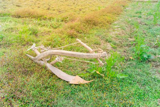 Fallow rice field with ancient plow at Lao Cai, North Vietnam. It is attached to a buffalo or a bull to turn soil. Traditional and manual agricultural tool concept.