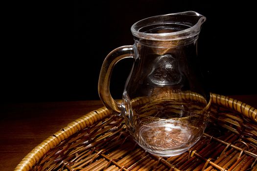 Empty glass jug in a wicker basket