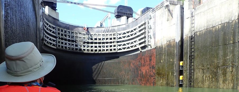 kayaking in a kayak in a river with large cement boat lock