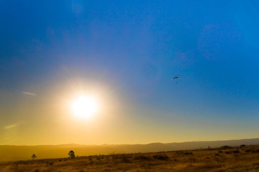 landscape of the eclipse in the mountains and paragliding in the sky