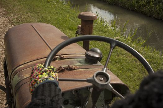 First-person image in driving a vintage tractor to cultivate farm fields and campaign.