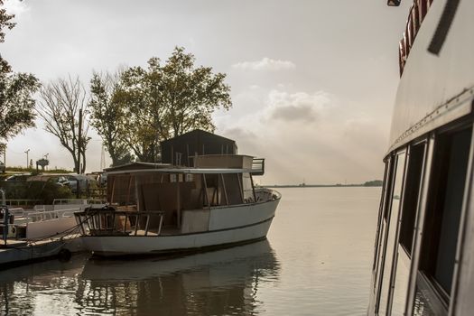 Small boat seen from a ferry sailing on the river Po in Italy at the delta point.