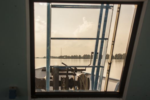 View of the river from the ferry window while sailing on the river itself.