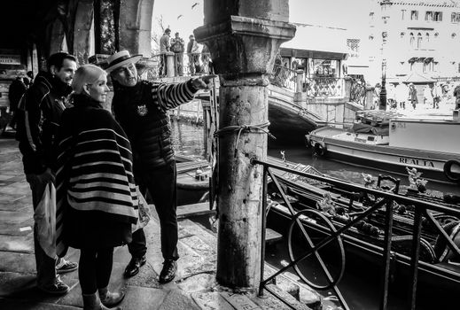 Tourists asking for information from a gondolier in Venice.