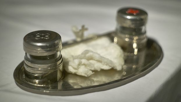 The oil of the catechumens and the chrism in their metal containers used during the Catholic religious rite of baptism.
