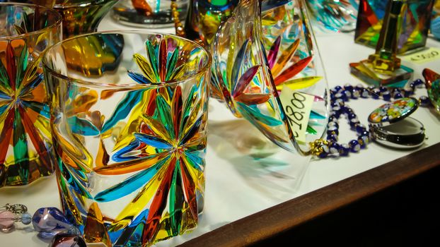 Showcase full of handmade colored glass glasses in Italy in Murano: An example of the precision and artistic value of Made in Italy.
