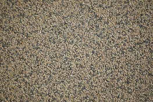 Texture of a wall covered with tiny colored and black pebbles that create an excellent background or texture for graphic projects.