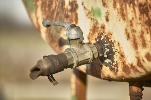 Detail of an old rusty tap of a cistern that was used to contain fuel for agricultural vehicles.