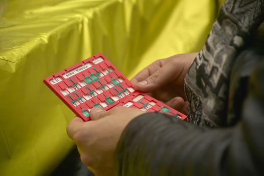 Bingo cards held by a boy while he is playing bingo. A luck game that can be a lot of fun.