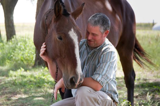 Smiling man with his horse in the Argentine countryside