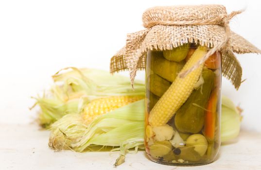 pickled corn and other vegetables in a jar