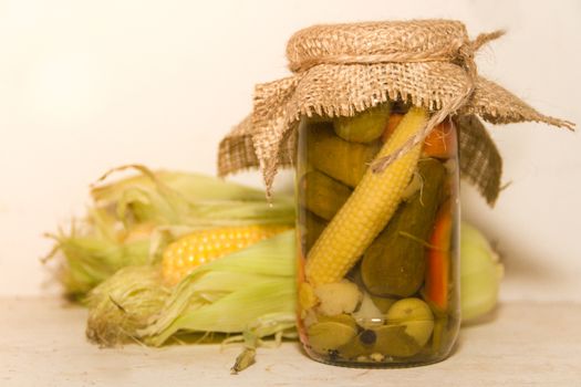 pickled corn and other vegetables in a jar