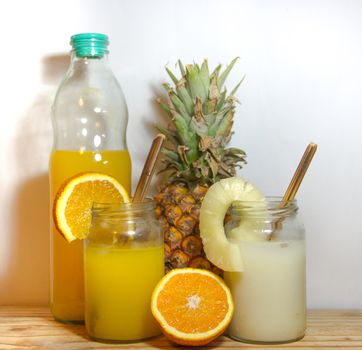 Juices smoothies and fresh pineapple and orange drinks with summer fruits