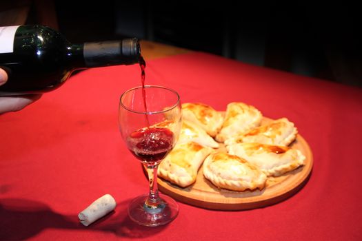 serving wine in the glass with empanadas plate typical South American food