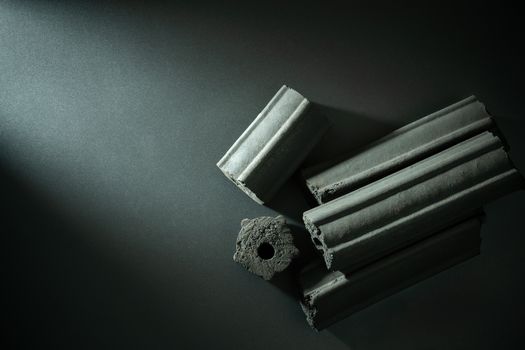 Carbon activated. Bamboo charcoal compressed in to stick on darkness background. Has the ability to absorb toxins in the human body. Concept of health care. Top view and copy space.