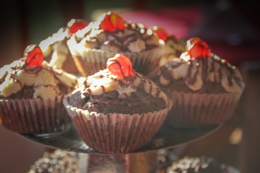 defocused background of cupcakes and muffins with chocolate and cherries