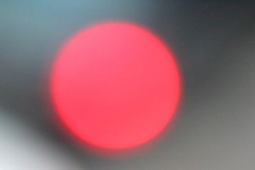 Defocused lights, red lens flare. Abstract blured background.