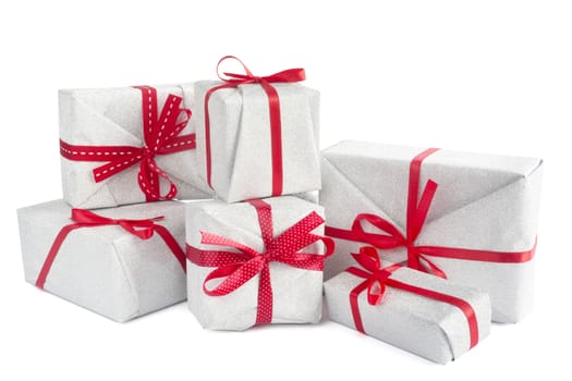 Heap of similar Christmas silver gift boxes with red ribbon decor isolated on white background