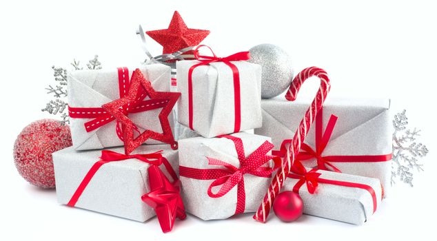 Heap of similar Christmas silver gift boxes with red ribbon decor stars baubles and candy cane isolated on white background