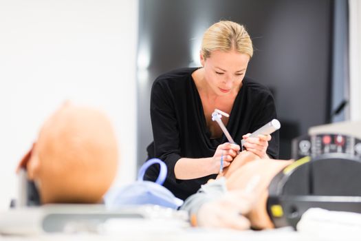 Medical doctor specialist expert displaying method of patient intubation technique on hands on medical education training and workshop.