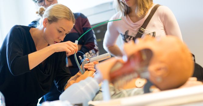 Medical doctor specialist expert displaying method of patient intubation technique on hands on medical education training and workshop.