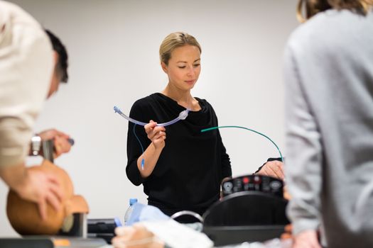 Medical doctor specialist expert displaying method of patient intubation technique on hands on medical education training and workshop.