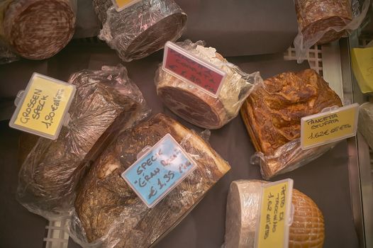 Texture of sliced meat for sale in the market inside the counter with prices displayed.