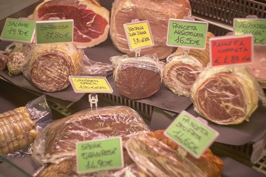 Lots of cold cuts inside the supermarket refrigerated counter ready to be sliced and sold to customers.