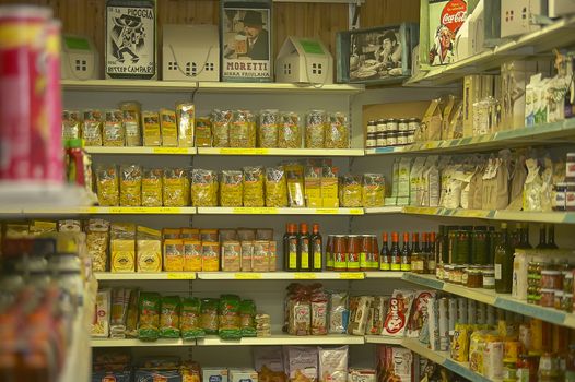 Detail of the shelves of a convenience store full of packs of various food.