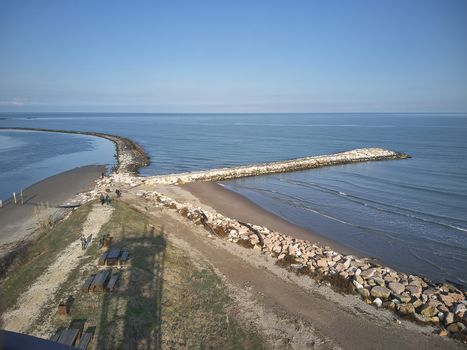 Aerial view of a system of dams of pebbles created to protect the beach of Rosolina in Italy; an example of how natural and artificial coexist in creating a unique landscape.