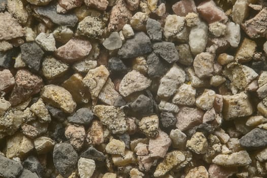 Very high definition texture of colored pebbles set in a wall.
