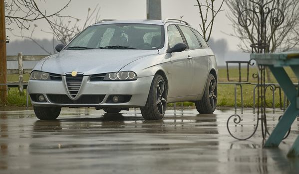 Car parked in a countryside landscape in the rain