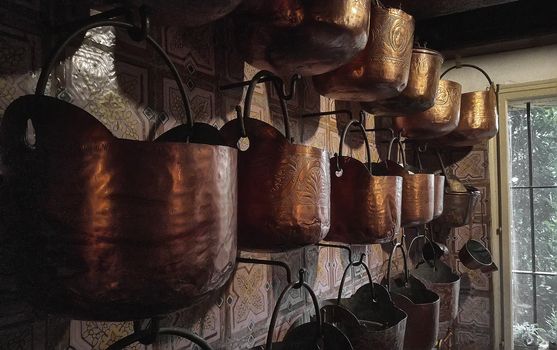 Interior of a vintage kitchen with hanging numerous vintage copper pots