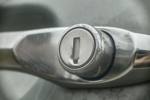 Detail of the lock of a broken-down car following a theft.