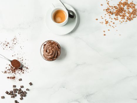 Sweet flat lay background. Chocolate, sugar, hazelnut cocoa spread, cocoa powder and coffee cup on white marble tabletop with copy space. Can use as mock up or special offer for cafe or confectionery