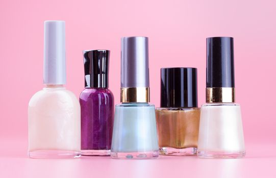 Variety of nail polish bottles with pink background