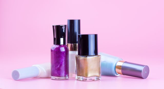 Variety of nail polish bottles with pink background