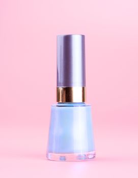 Bottle of nice pearly blue nail polish, pink background
