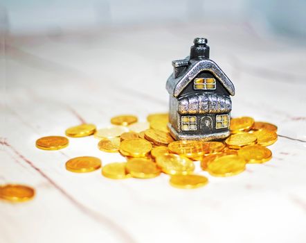 The house stands on a pile of coins, the concept of cash savings, loans..