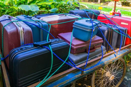 old luggage cart filled with suitcases that are secured by a rope, Nostalgic baggage transportation