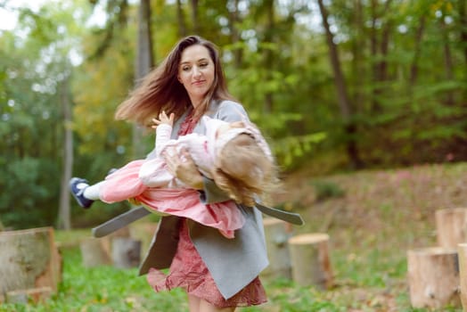 Beautiful little girl on a walk in the park on a sunny day. Autumn day